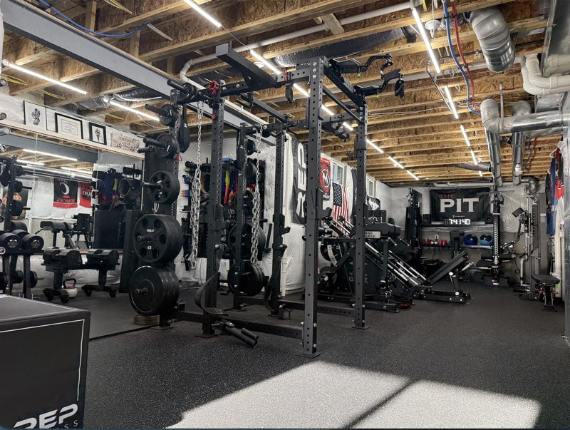 The Pit home gym build with racks, cable machines, storage, and open training space
